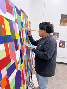 Student painting a canvas.