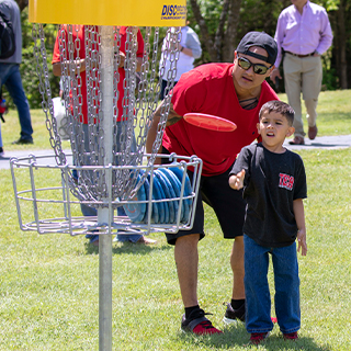 A man and young boy playing disc golf