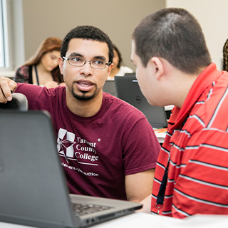 SI instructor helping a student on a laptop