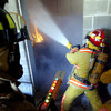 Firefighters in training tackle a blazing building. Click for details