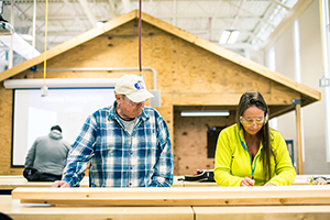 A man and a woman working on a construction project with wood pieces