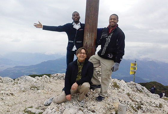 Three people pose around the peak of the Alps