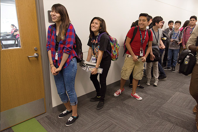 Crystal waits outside a classroom door with a line of other students