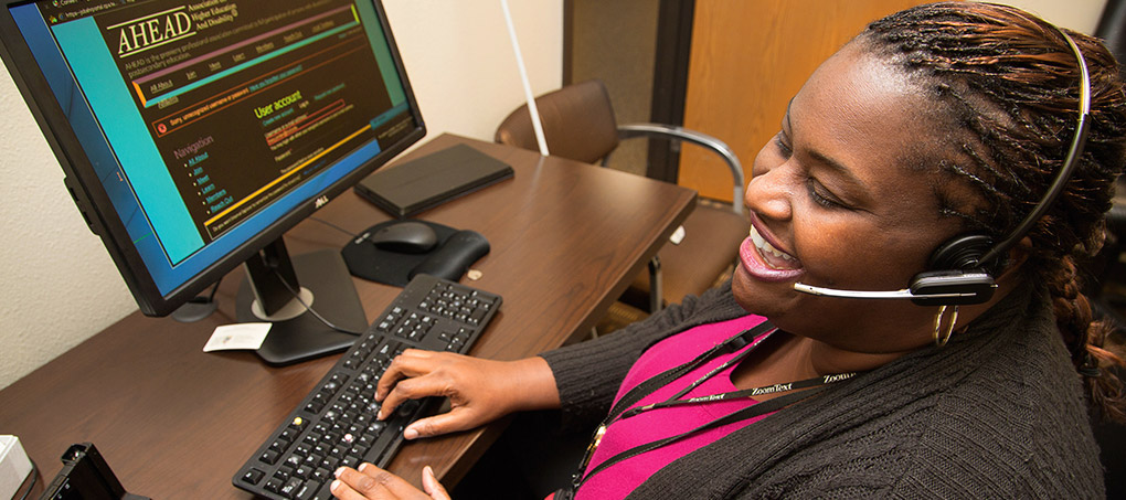 Tracy Jordan smiles and laughs while working on her computer