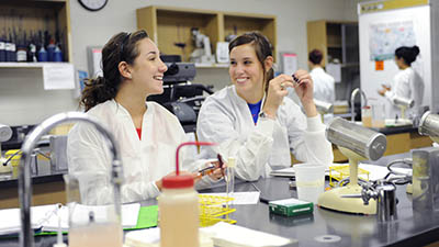 Two students share a funny moment in a lab classroom