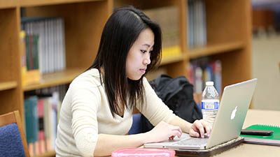 A student uses her laptop in the library
