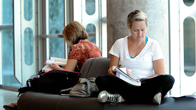 Two students study in the lobby on a circular couch