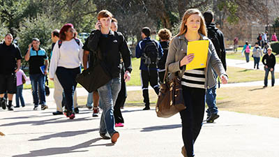 Students stride across the campus on a beautiful fall day