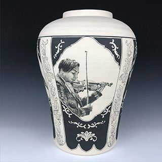 A picture of a vase with a black and white drawing painting of a man playing violin on it.