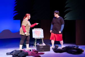 2 characters standing on a stage and debating the meaning behind a painting.