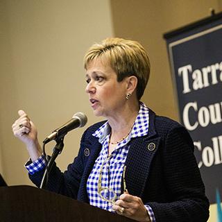 Woman speaking at the front of the room