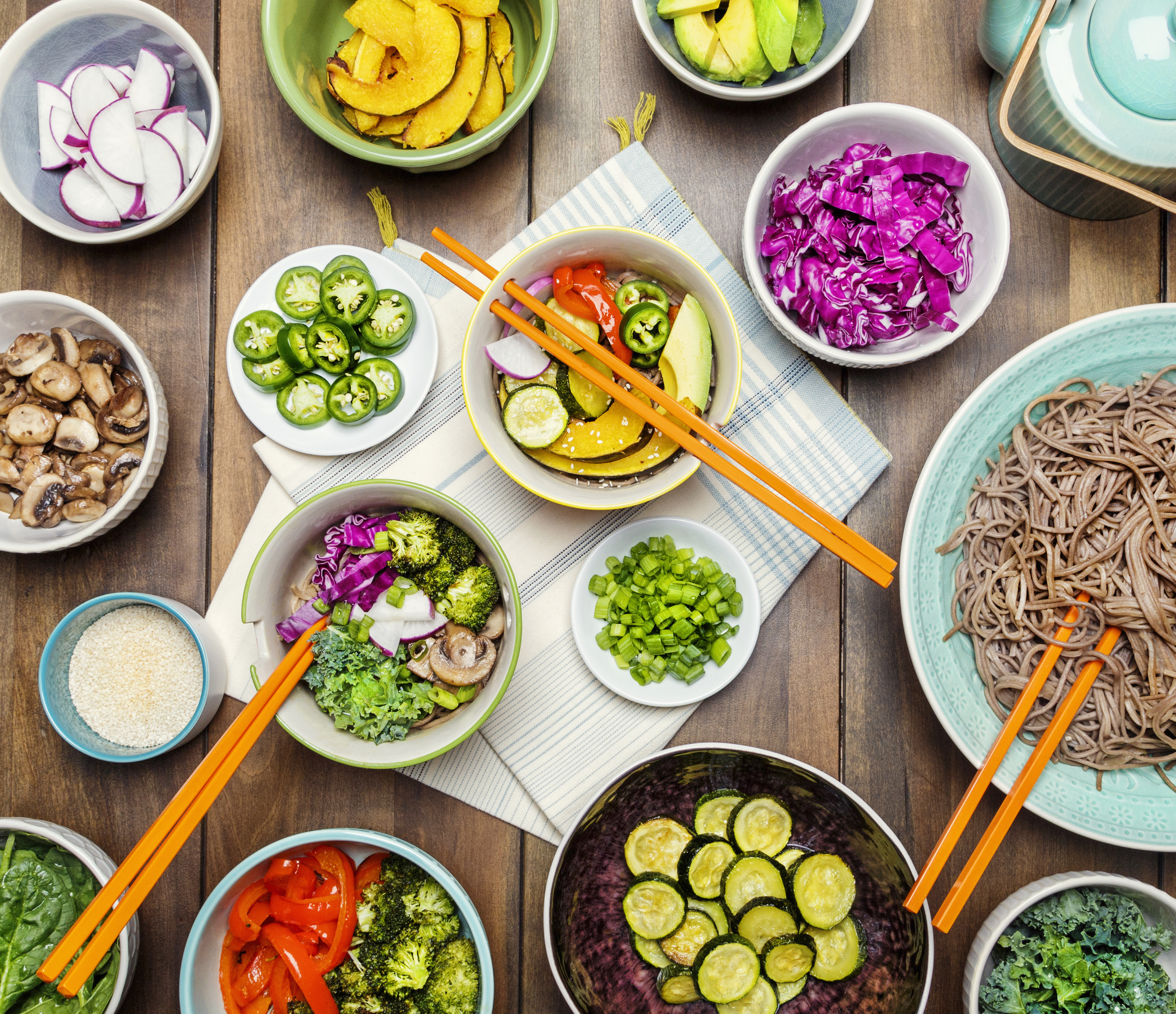 bowls of the igredients: cut vegetables, sesame seeds and noodles