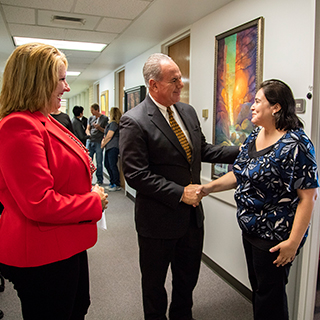 Eugene Giovannini shaking the hand of a staff member