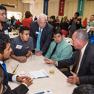 Eugene Giovannini sitting at a table with students