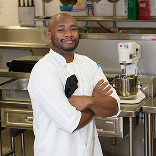 Nathan Price standing in a kitchen