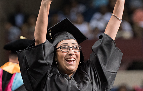 Female student with her diploma raised in her hand