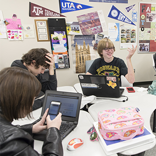 Two high-school boys sitting at a table with laptops