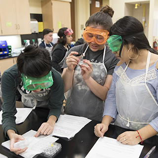 Three high school girls wearing safety goggles