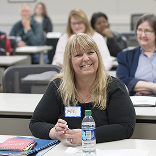 Woman sitting in a classroom, smiling