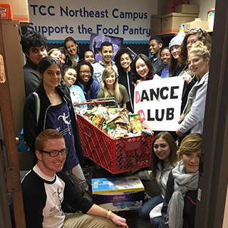 Dance students posing with a sign