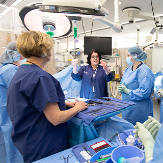 Students in scrubs learning about surgical tools