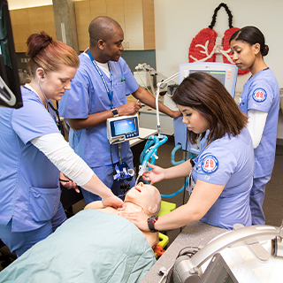 Students practicing with a dummy