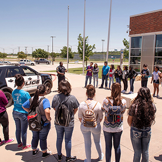 Students standing around a police car