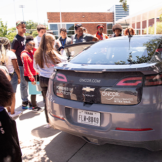 Students looking at an oncor car