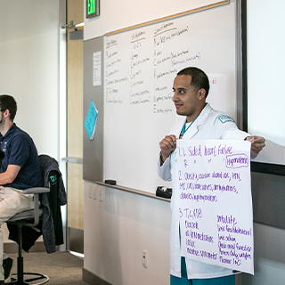 Student standing at the front of a classroom presenting