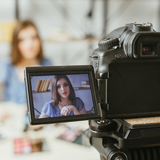 view from behind a camera of an in-progress interview with a woman