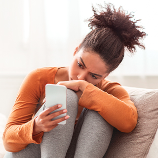 woman sitting with her knees to her chest