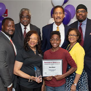 group of people around boy holding certificate