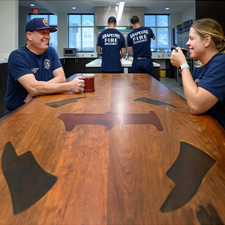 Father and daughter sitting together with mugs in the firehouse