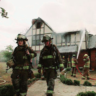 Father and daughter leaving a home after it's been on fire