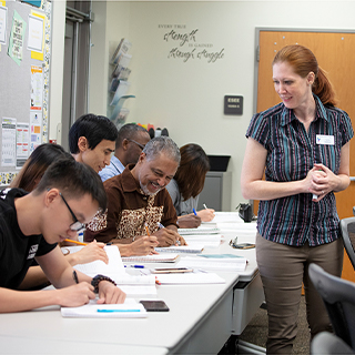 teacher looking over at students working