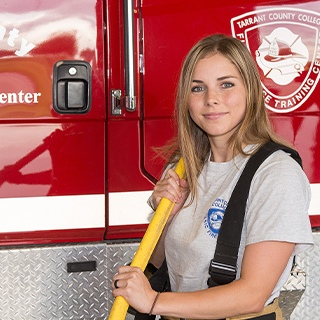 woman holding axe in front of fire engine