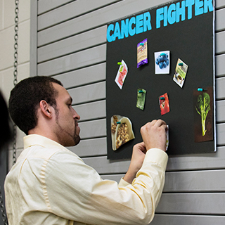 Man pinning food pictures to a bulletin board