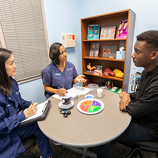 Dietetics students speaking to a young man