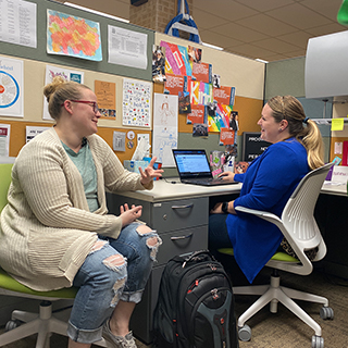 Gabby Hall talking to another woman in an office