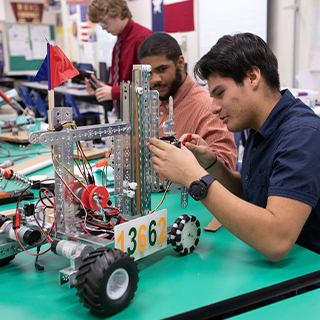 male students putting together a robot