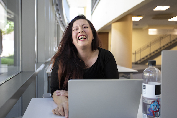 Katie, working on her latop, laughs for the camera