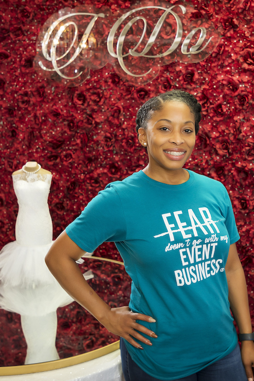 Timesha Brown stands in front of a green, leafy backdrop