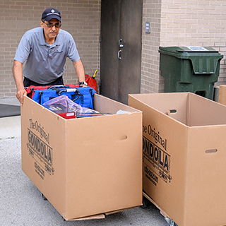 Employee pushing a cart full of desk supplies outside MOC