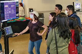 students gathered around a video screen