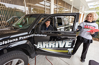 student sitting in drivers seat of vehicle