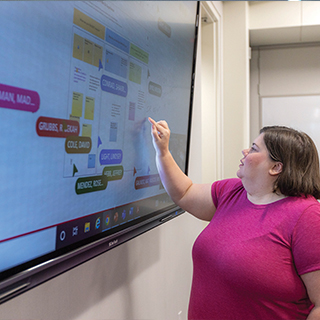 woman touching smartboard