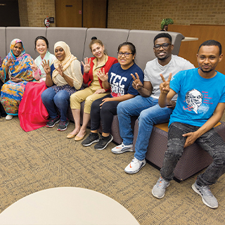 Group of international students holding their fingers up to represent how many years they have lived in the United States