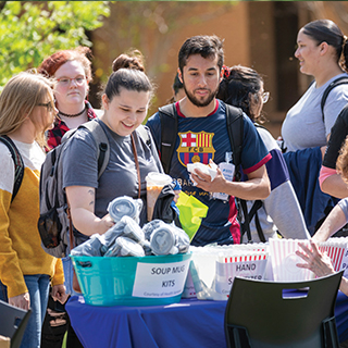 Students in line to pick up free soup mug kids and hand sanitizer.