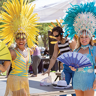 Two women dressed in traditional Carnival dresses from South America.