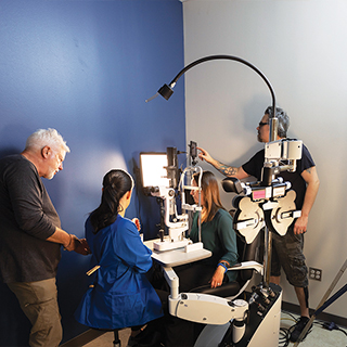 Some last-minute adjustments are made to a lab coat worn in the commercial.